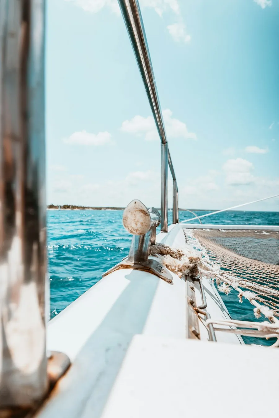 Bow of a white sailboat with rigging and open sea beyond